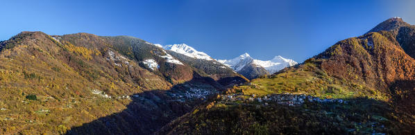 An early snowfall has capped some of the peaks in the Albaredo Valley of Bitto, with the small village of Bema on the right and the small village of Albaredo in the dark Orobie Alps, Valtellina, Sondrio, Lombardy, Italy Europe