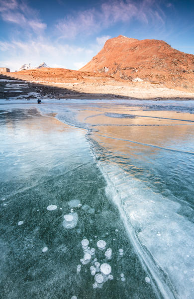 Frozen lake Montespluga at dawn, Chiavenna Valley, Sondrio province, Valtellina, Lombardy, Italy