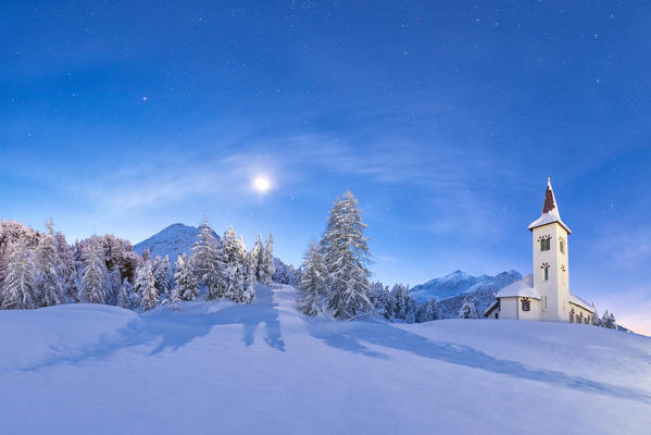 Moonlight on Chiesa Bianca surrounded by snow, Maloja, Bregaglia Valley, Canton of Graubunden, Engadin, Switzerland