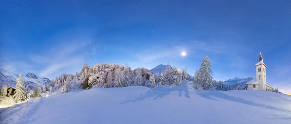 Panoramic of snowy landscape and Chiesa Bianca at night, Maloja, Bregaglia Valley, Canton of Graubunden, Engadin, Switzerland