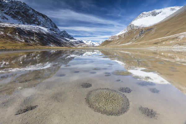 Snowy peaks reflected in water, Albula Pass, Bergün, Canton of Graubünden, Engadine, Switzerland