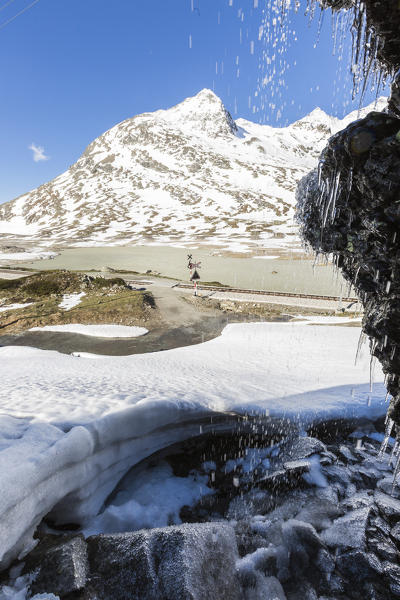 Railway on the shore of frozen Lago Bianco, Bernina Pass, canton of Graubunden, Engadine, Switzerland