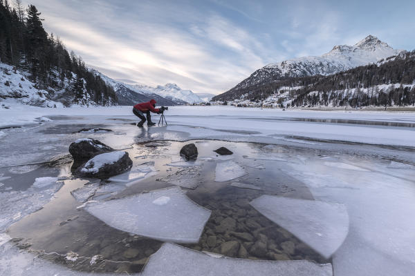 Photographer at dawn on frozen Lake Champfer, Silvaplana, Maloja Region, canton of Graubunden, Engadin, Switzerland