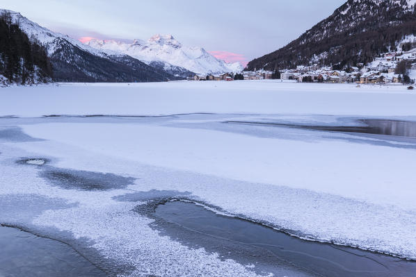 Village of Silvaplana and Piz Da La Margna seen from icy Lake Champfer, St.Moritz, canton of Graubunden, Engadin, Switzerland