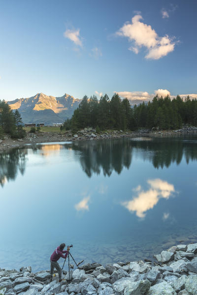 Photographer on the shore of Lago Azzurro, Spluga Valley, province of Sondrio, Valtellina, Lombardy, Italy