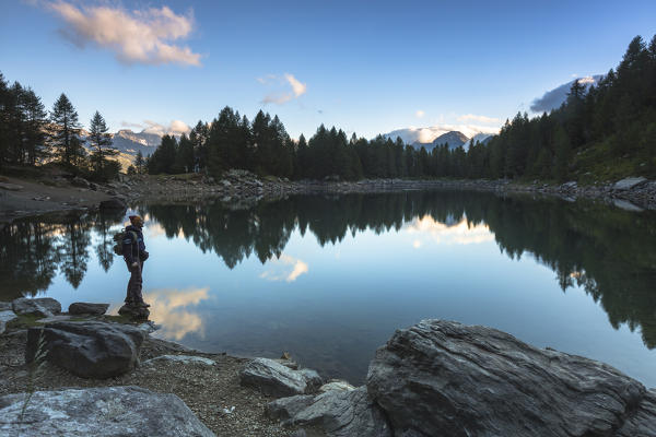 Hiker on the shore of Lago Azzurro, Spluga Valley, province of Sondrio, Valtellina, Lombardy, Italy