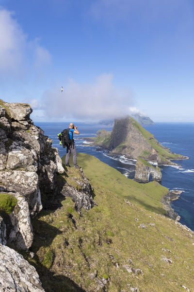 Photographer looks towards Drangarnir rock, Vagar Island, Faroe Island