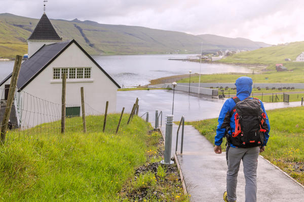 Hiker at church of Nordskali, Eysturoy island, Faroe Islands, Denmark