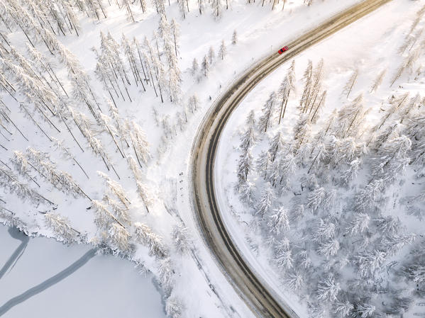 Aerial view of road and snowy woods around Lake Sils, Plaun da Lej, Maloja Region, Canton of Graubunden, Engadin, Switzerland