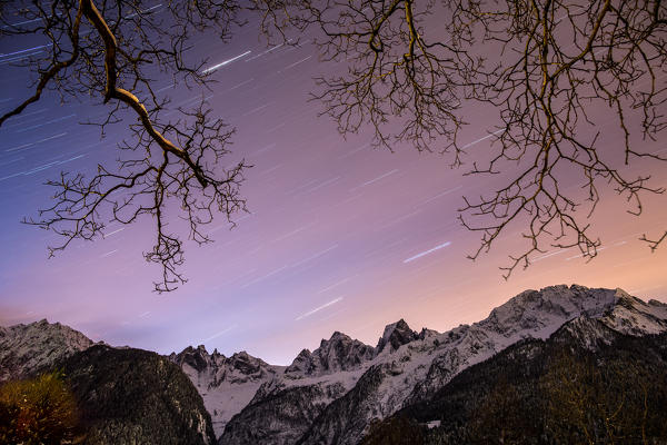 Star trail in the sky over Pizzo Badile and Pizzo Cengalo, two famous peaks in Bondasca Valley. Switzerland. Europe