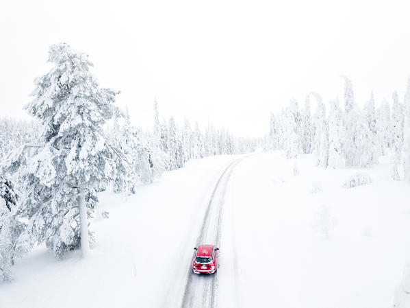 Elevated view of car along the snowy road in the icy forest, Pallas-Yllastunturi National Park, Muonio, Lapland, Finland