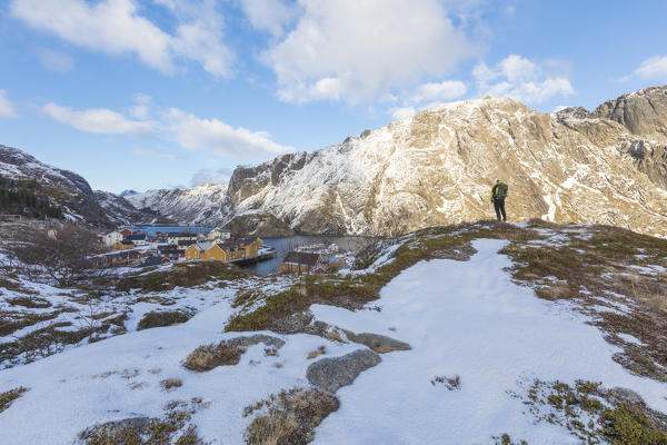 Hiker on rocky peak, Nusfjord, Lofoten Islands, Norway