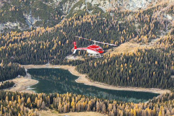 Aerial view of helicopter in flight on Lake Palù during autumn, Valmalenco, Valtellina, Lombardy, province of Sondrio, Italy