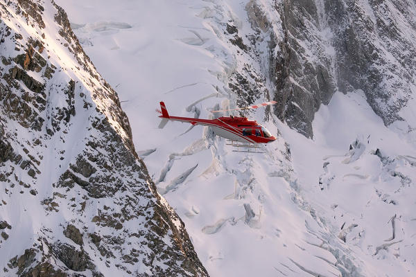 Helicopter in flight on glacier of Monte Disgrazia, Valmalenco, Val Masino, Valtellina, Lombardy, province of Sondrio, Italy