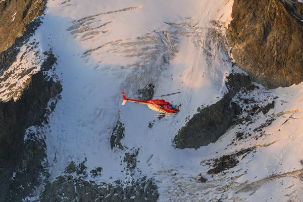 Helicopter in flight on glacier of Monte Disgrazia, Valmalenco, Val Masino, Valtellina, Lombardy, province of Sondrio, Italy