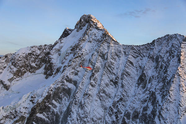 Helicopter in flight on the north face of Monte Disgrazia, Valmalenco, Val Masino, Valtellina, Lombardy, province of Sondrio, Italy
