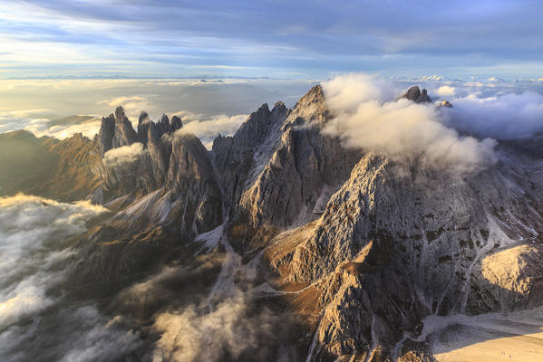 Aerial view of fog hiding the peaks of the Odle group at sunset. Puez Odle National Park. Dolomites. Independent Province of Bolzano. Trentino Alto Adige. Italy. Europe