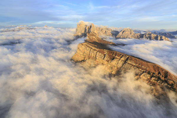 The Odle range emerging from a sea of clouds at sunset. In the foreground the Seceda in the Natural Parc of Puez Odle. Dolomites. Trentino Alto Adige. Italy. Europe