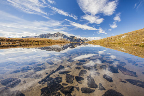 Crystal clear water of a little lake close to the Stelvio pass. In the background the Piz Umbrail. Stelvio National Park. Sondrio. Valtellina. Lombardy. Italy. Europe