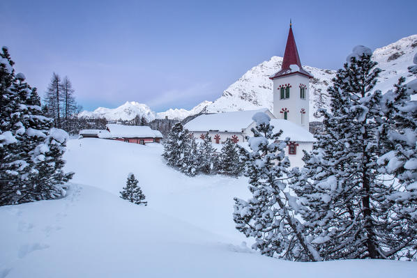 Freezing winter sunrise at the Saint Gaudenzio's church at the Maloja Pass after a memorable snowfall. Engadine. Canton of Graubünden. Switzerland. Europe