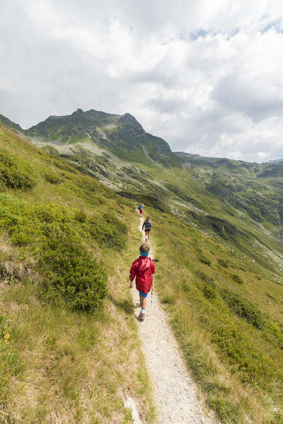 Children walk on footpath towards Lake Emet, Andossi, Spluga Valley, Sondrio province, Valtellina, Lombardy, Italy