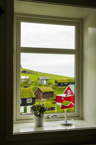 Iconic houses with grass roof seen through a window, Mykines island, Faroe Islands, Denmark