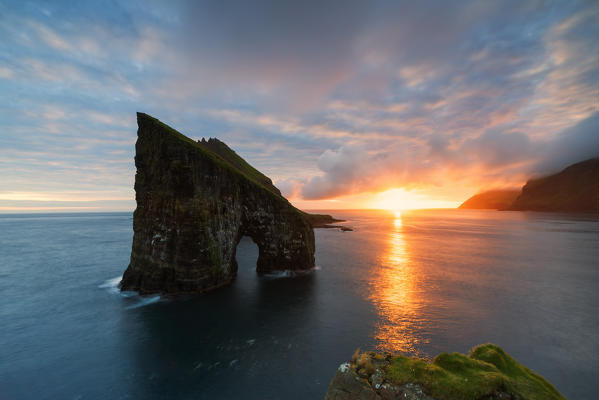 Sunset on the majestic natural arch of Drangarnir rock, Vagar island, Faroe Islands, Denmark