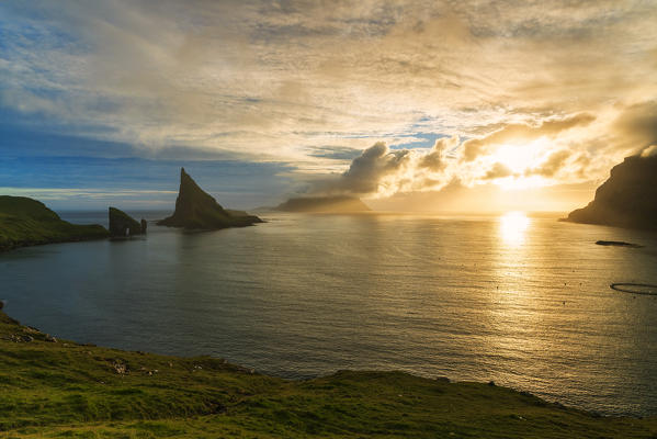 Sunset on the calm ocean and Drangarnir rock, Vagar island, Faroe Islands, Denmark