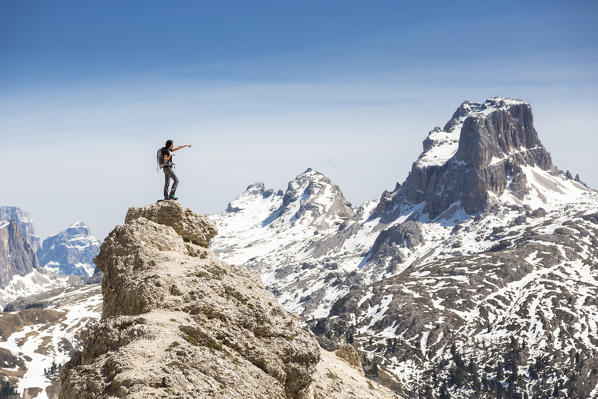 a hiker stands on a peak and looks at the Mount Averau near Cortina d'Ampezzo, Belluno province, Veneto, Italy