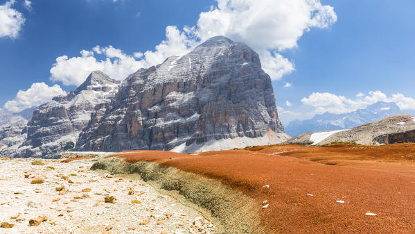 A view of the Tofana di Rozes with a strip of red and green land in the foreground, Belluno province, Veneto, Italy
