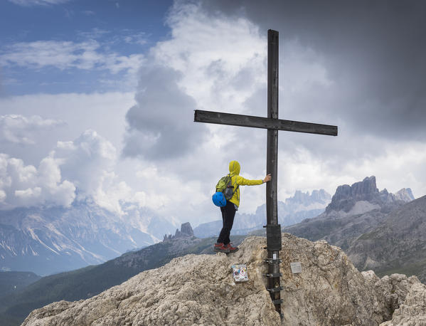 A climber at the top of the Sass de Stria with the Dolomiti Bellunesi National Park in the background, Belluno province, Veneto, Italy