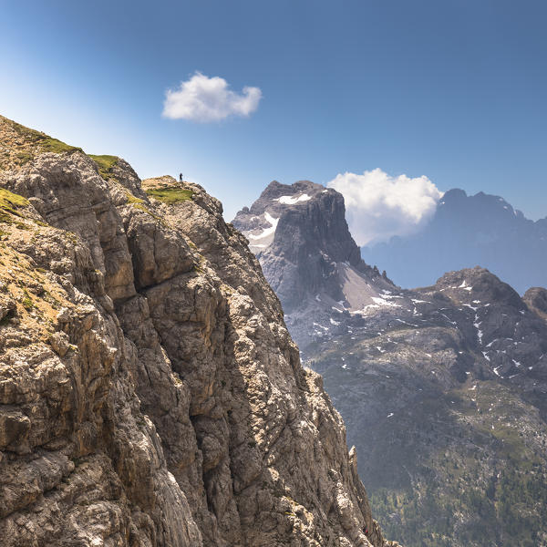 A view of the Dolomiti Ampezzane Natural Park (Eastern Dolomites) with a lonely climber in foreground and the Averau Peak in the background, Belluno province, Veneto, Italy