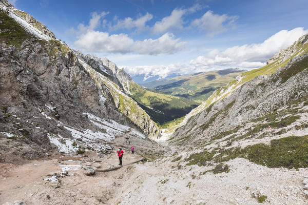 Hikers along an alpine path towards the Peitlerkofel into the Natural Park Puez Geisler, Bolzano province, South Tyrol, Trentino Alto Adige, Italy