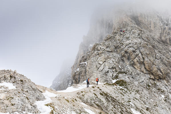 Hikers along an alpine path towards the Peitlerkofel into the Natural Park Puez Geisler, Bolzano province, South Tyrol, Trentino Alto Adige, Italy
