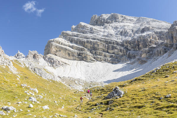hikers along an alpine path into the Natural Park Puez Geisler, Bolzano province, South Tyrol, Trentino Alto Adige, Italy