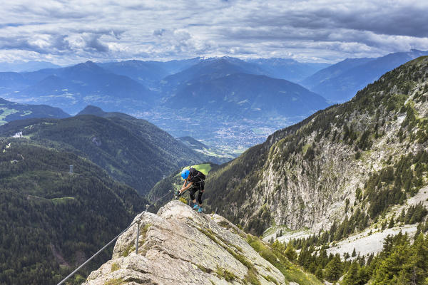 a challenging passage along the via ferrata Heini Holzer with the city of Merano in the background, Bolzano province, South Tyrol, Trentino Alto Adige, Italy