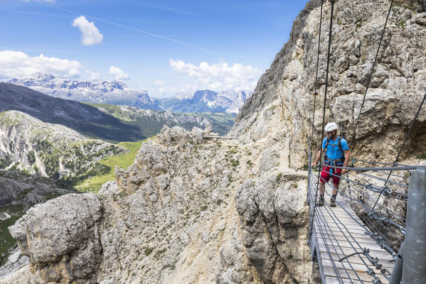 A climber on the tibetan bridge along the via ferrata Kaiserjäger on mount Lagazuoi, Bolzano province, South Tyrol, Trentino alto Adige, Italy