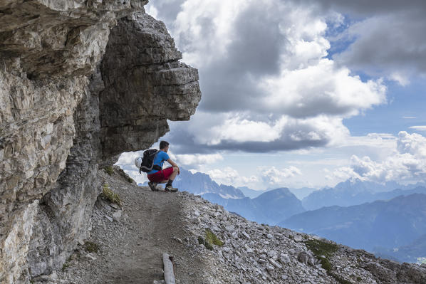 A climber on mount Lagazuoi along the via ferrata Kaiserjäger looking towards the landscape, Bolzano province, South Tyrol, Trentino alto Adige, Italy