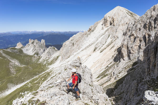 A climber along the via ferrata Günther Messner on the Aferer Geisler with Tullen Peak in the background, Bolzano province, South Tyrol, Trentino Alto Adige, Italy