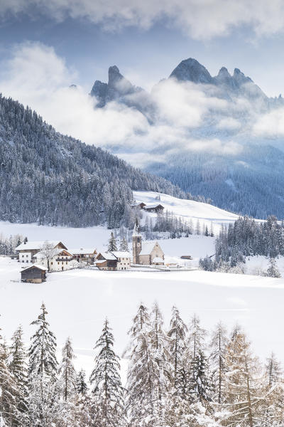 Winter landscape in Villnöss with Geisler Group in the background and a small alpine village in foreground, Bolzano province, South Tyrol, Trentino Alto Adige, Italy