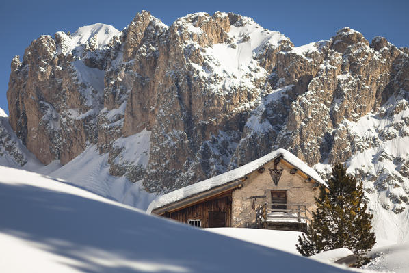 a winter view of an old hut with a massive rocky wall in the background, Val Gardena, Bolzano province, South Tyrol, Trentino Alto Adige, Italy, Europe