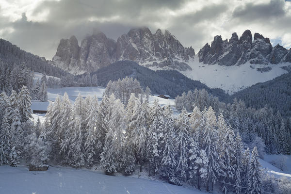 an impressive landscape of the Puez Geisler natural park, after a snowfall where the sun comes out from dark clouds, Villnöss, Bolzano province, South Tyrol, Trentino Alto Adige, Italy, Europe