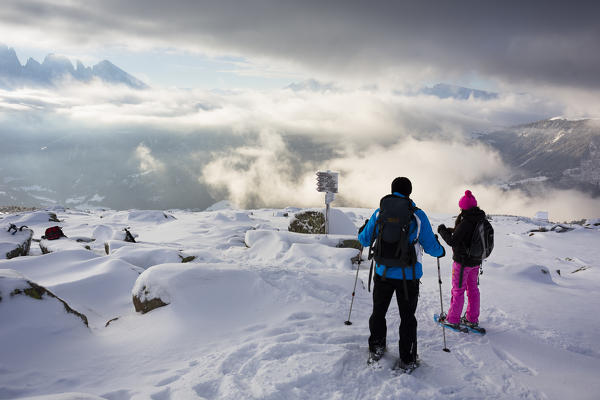 a couple of tourists in a early morning winter trekking in Val Gardena, Bolzano province, South Tyrol, Trentino Alto Adige, Italy, Europe