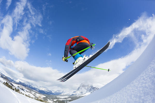 winter view of the Seiser Alm with a skier jumping off a hill, Bolzano province, South Tyrol, Trentino Alto Adige, Italy, Europe