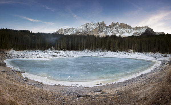 a panoramic view of the whole Karersee during the winter season with the latemar Gruppe in the background