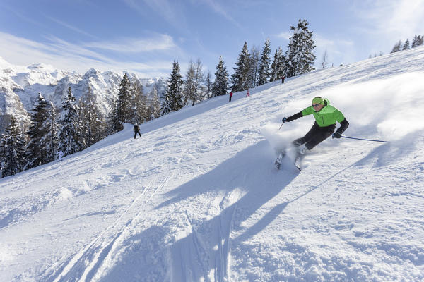 a skier is skiing along the slopes in the Folgarida ski resort with Brenta Group in the background