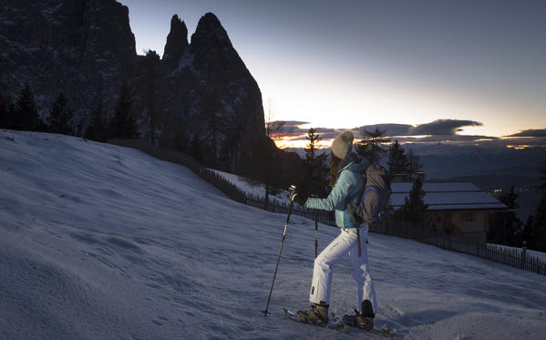 a winter trekking with snowshoes on the Seiseralm with the Schlern in the background during the sunset, Bolzano province, Trentino Alto Adige, Italy, Europe
