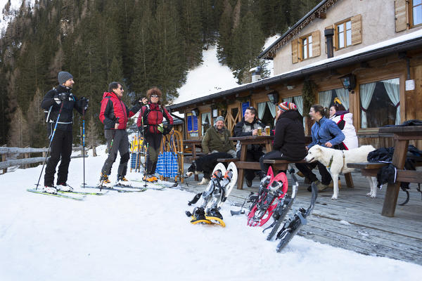 a snapshot of friend are talking in a relaxing atmosphere out of an alpine hut, Trento province, Trentino Alto Adige, Italy, Europe