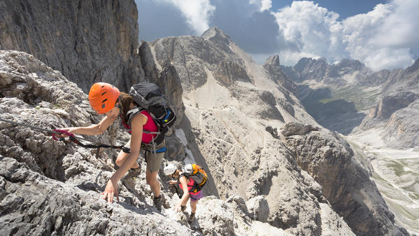a view of two hikers climbing on the Rosengarten mountain along the via ferrata 