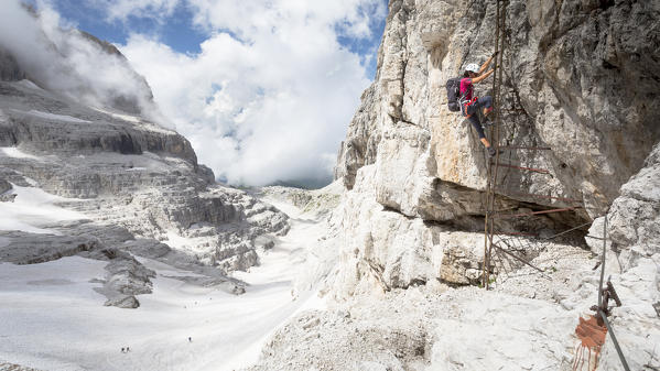 a view of a hiker going down from a vertical ladder on the famous via ferrata 